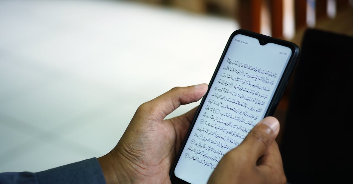 A man reading the Quran on a smartphone inside a mosque, symbolizing modern technology meeting traditional faith.