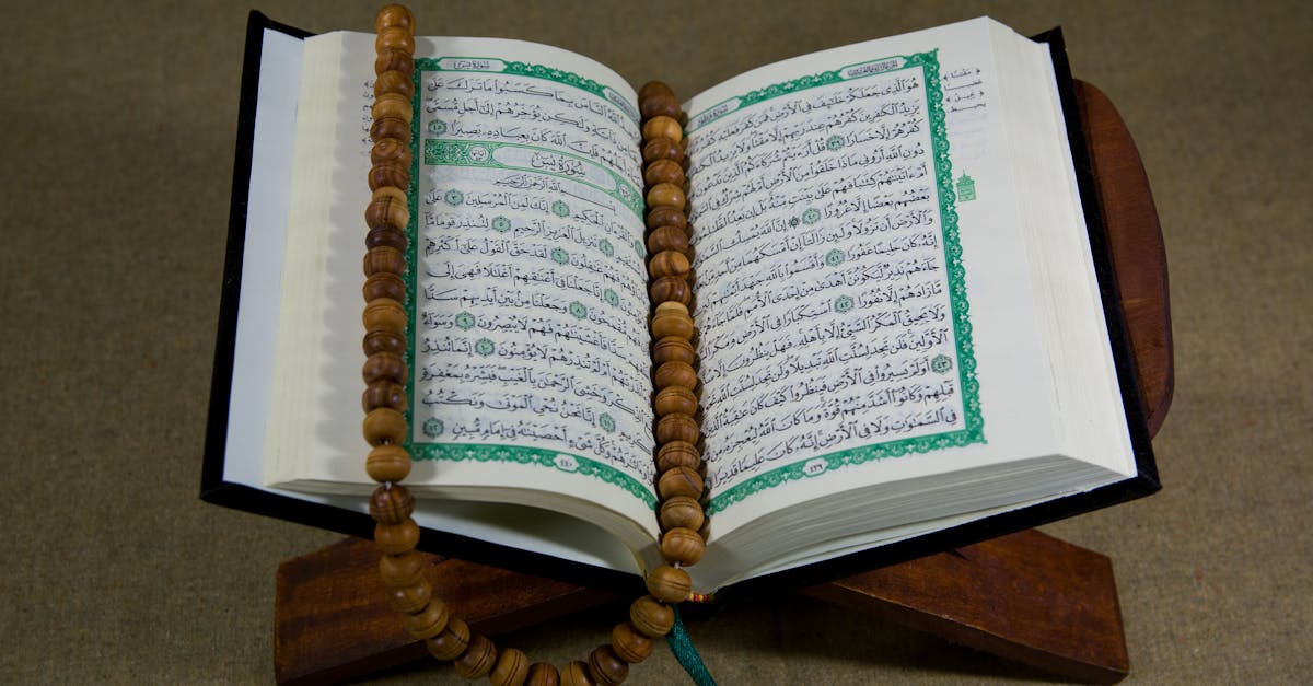 An open Quran with prayer beads displayed on a wooden stand, symbolizing Islamic faith and tradition.