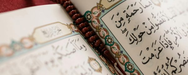 Detailed image of an open Quran with prayer beads, symbolizing Muslim culture and spirituality.